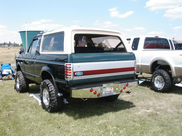 Green and white 1994 Ford Bronco rear view, lifted with chrome bumper and red lights