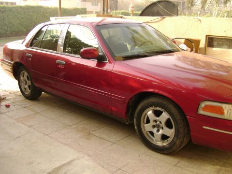 1998 Ford Crown Victoria - This red 1998 Ford Crown Victoria is shown from a 3/4 front angle.