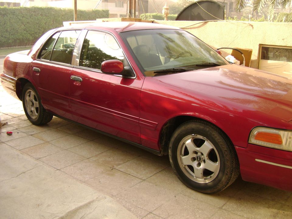 Red 1998 Ford Crown Victoria sedan, 3/4 front view