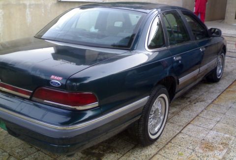 1998 Ford Crown Victoria - Rear three-quarter view of a 1998 Ford Crown Victoria, a dark green exterior, chrome accents, and whitewall tires.