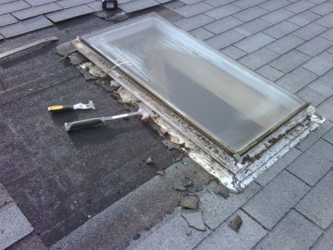 1996 Ford Bronco - A skylight on a roof shows signs of wear and tear, with roofing tools nearby.