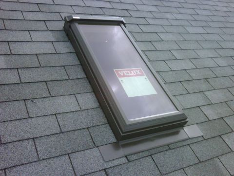 1996 Ford Bronco - A VELUX skylight is installed on a gray asphalt shingle roof, showing a label on the glass.
