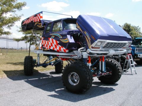 1994 Ford Bronco - This heavily modified truck features a custom paint job with checkerboard accents and an elevated chassis with oversized tires.