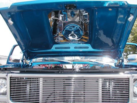 1994 Ford Bronco - Close-up of a blue truck's engine bay, showing a polished engine and chrome air filter.