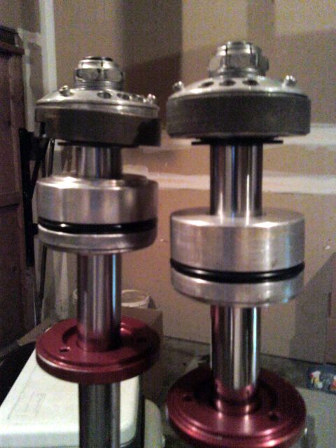 1984 Ford Bronco - Pair of aftermarket shock absorbers shown with red bases and silver bodies.