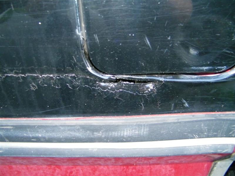 Damaged black paint on vehicle door seam
