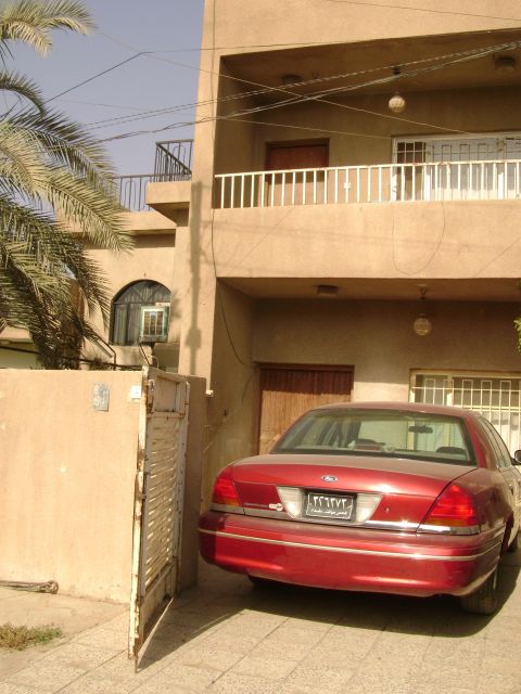 1998 Ford Crown Victoria - A red sedan is parked in front of a building, with a visible license plate and a watermark at the bottom.