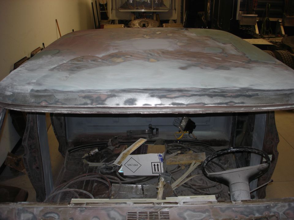 Vehicle roof and interior with exposed wiring and steering wheel, undergoing bodywork
