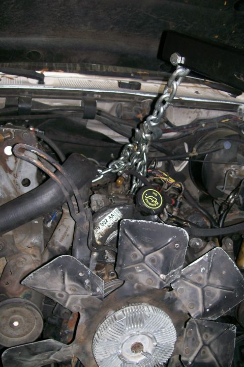1992 Ford C-350 (Centurion Conversions) - The engine bay of a 1992 Ford C-350 (Centurion Conversions) shows a chain hoist rigged to the hood for engine work.