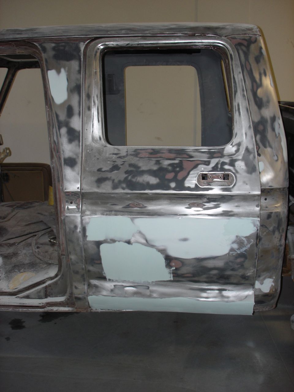1979 Ford F-250 crew cab body panels undergoing repair, showing primer and body filler