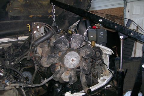1992 Ford C-350 (Centurion Conversions) - The engine is suspended by a hoist, indicating it is being removed or installed.