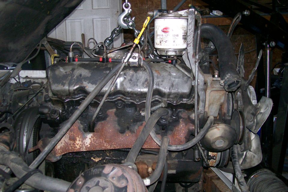Engine with oil filter and fan assembly, being lifted by a chain hoist
