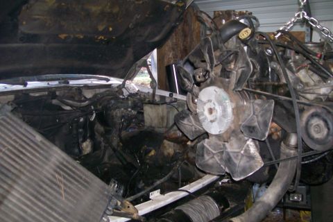 1992 Ford C-350 (Centurion Conversions) - The engine is being lifted out of the vehicle, showing the engine bay and radiator.