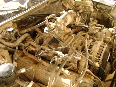 1998 Ford Crown Victoria - The engine bay of a 1998 Ford Crown Victoria shows significant dust and dirt accumulation on its components.