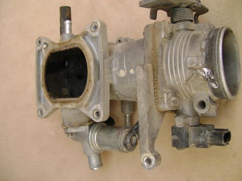 1998 Ford Crown Victoria - Close-up of a used throttle body assembly, showing internal carbon buildup.
