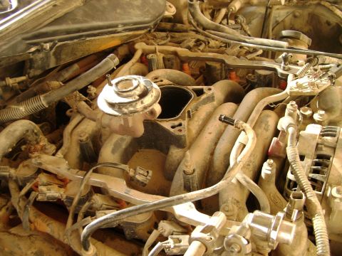 1998 Ford Crown Victoria - Close-up view of a dusty engine bay, with the intake manifold disassembled.