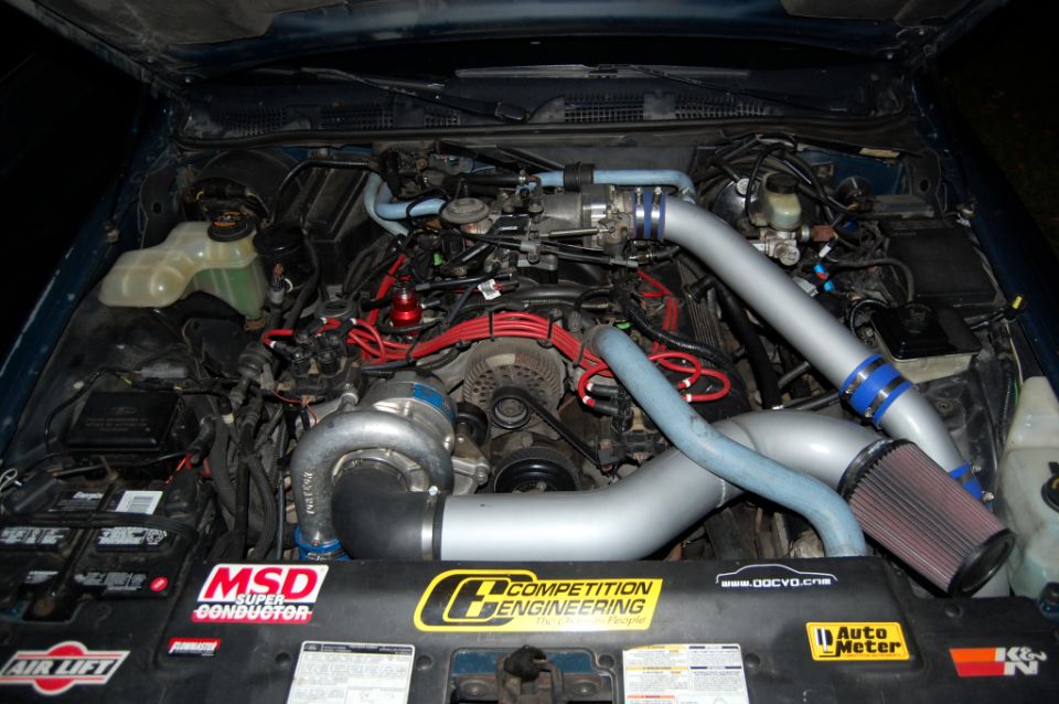Engine bay with turbocharger and custom intake piping
