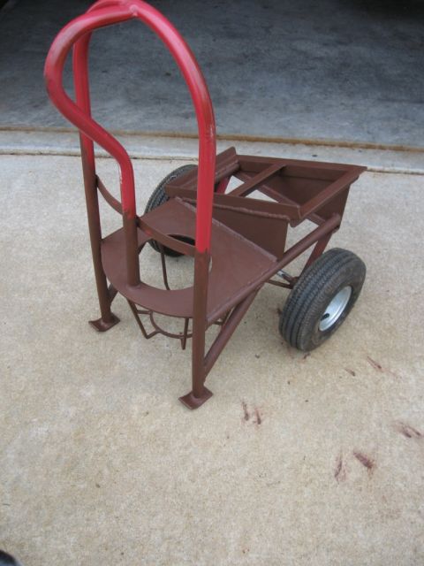 1995 Ford F-150 - A custom-built welding cart, painted red and brown, sits on a concrete surface.