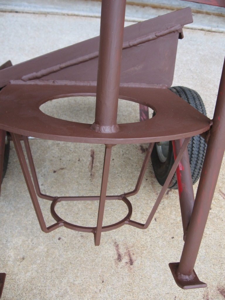 Brown painted metal welding cart with a wheel visible in the background