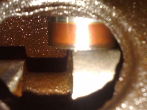 1978 Ford Bronco - Close-up view of the interior of an engine oil pan, showing some oil and metal components.