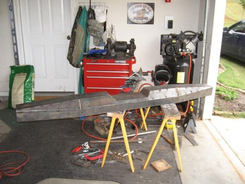 1995 Ford F-150 - A custom metal fabrication project is displayed in a garage setting, surrounded by tools and equipment.