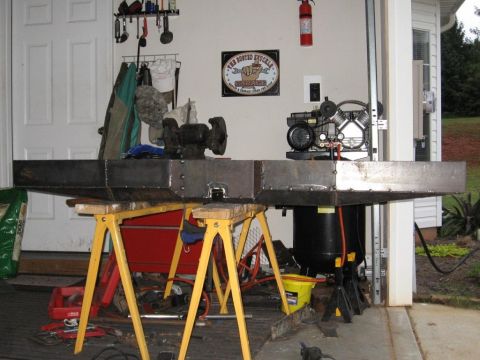 1995 Ford F-150 - A fabricated metal bumper assembly is supported by sawhorses, with an air compressor mounted on top.