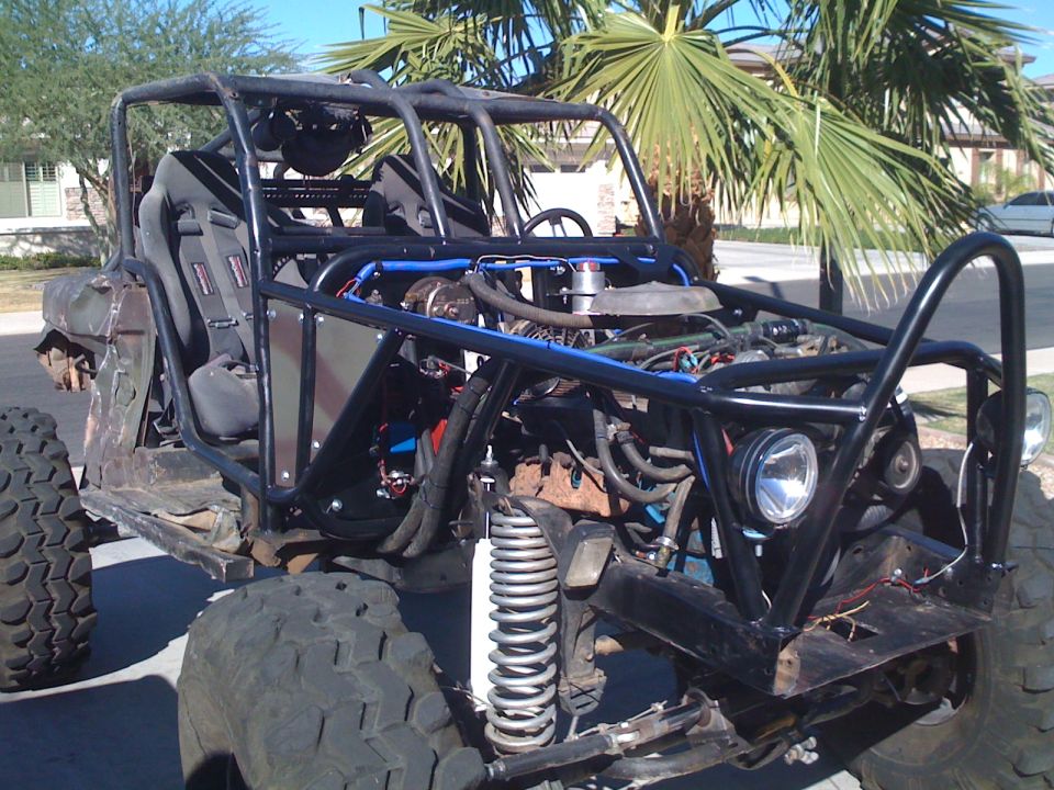 Custom buggy with roll cage, large tires, and exposed engine. Front view