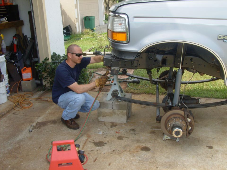 Mike cutting off hangers so new 1" longer hanger can be welded on.