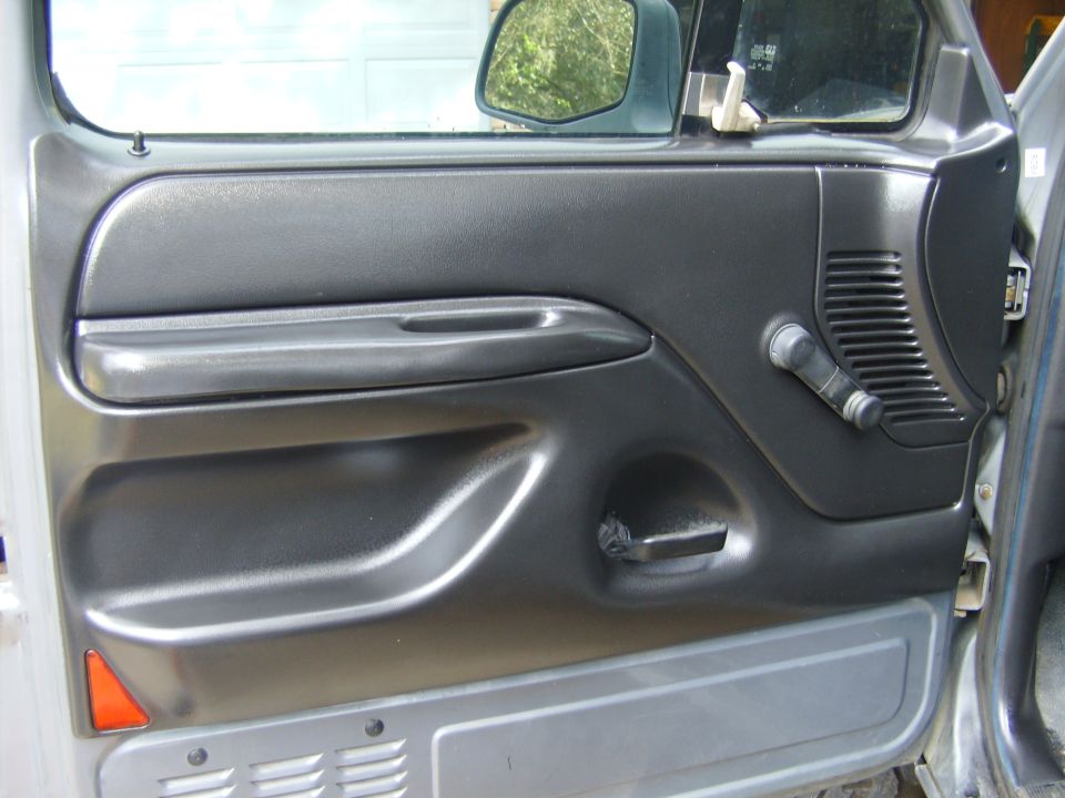 Gray interior door panel of a 1990s Ford truck with door open