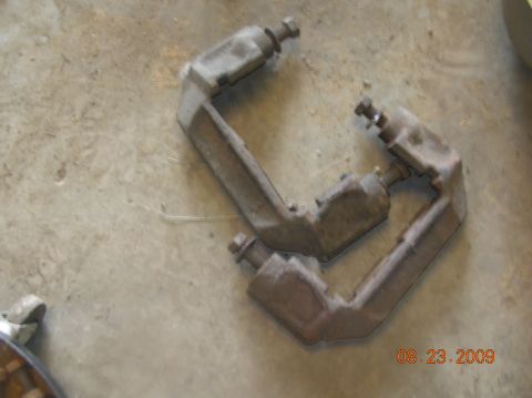 1991 Ford F-150 - Two brake caliper brackets are shown on a concrete floor.