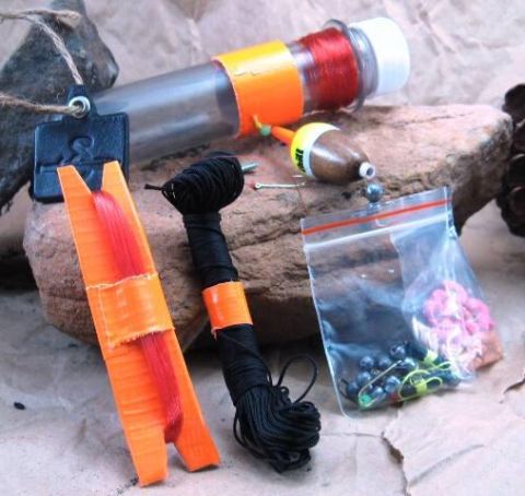 1991 Ford Bronco - A collection of fishing gear including line, a bobber, weights, and hooks is laid out on a textured surface.
