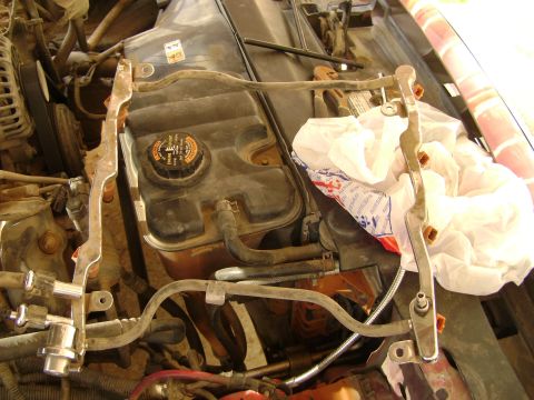 1998 Ford Crown Victoria - Close-up view of a vehicle's engine bay, focusing on the fuel rail assembly and coolant reservoir.