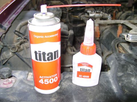 1998 Ford Crown Victoria - Titan Activator 4500 spray and EC-4500 adhesive bottle are placed on a vehicle's engine bay.