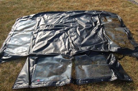 1994 Ford Bronco - Black soft top with clear windows and floor mats laid out on the grass. The registry claims it is for a 1994 Ford Bronco, but this cannot b…