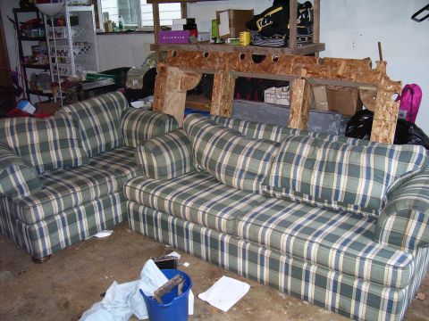 1991 Ford Bronco - A cluttered garage scene two plaid couches and various stored items.