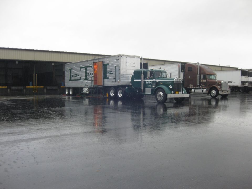 Green semi-truck with LTI trailer parked at loading dock