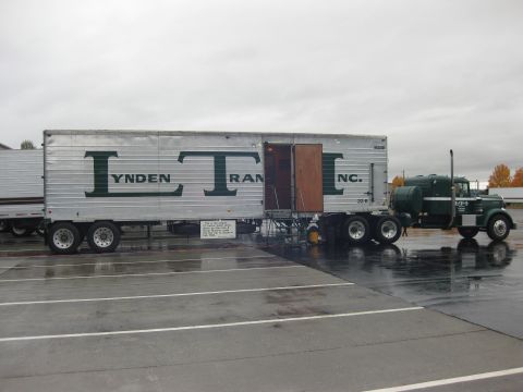 1981 Kenworth W900A - A green semi-truck is parked next to a silver trailer with 'LYNDEN TRAN INC.' written on the side.