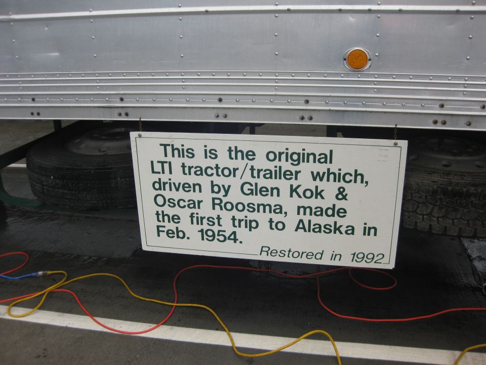 Side view of a tractor trailer with a sign detailing its history and restoration date