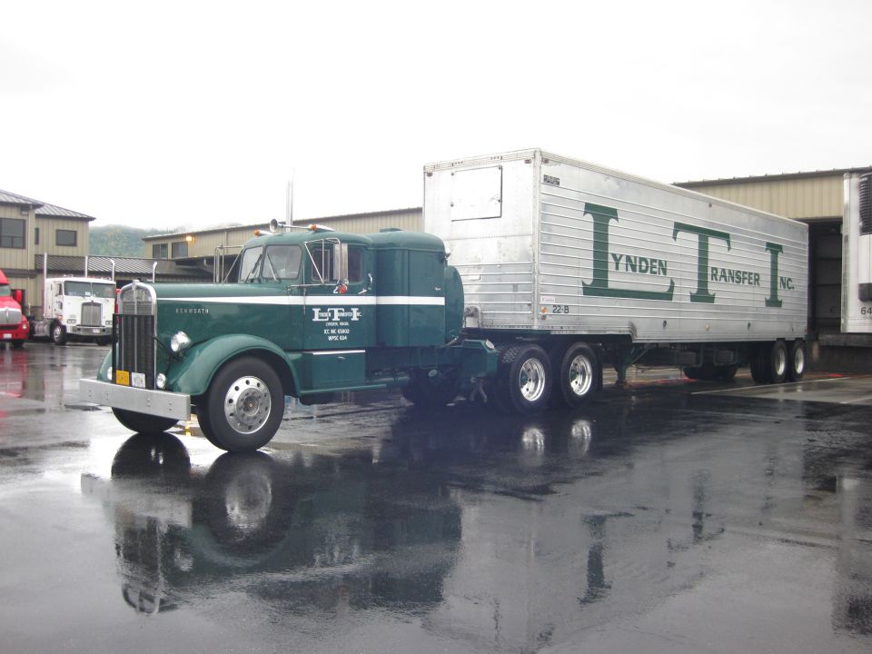 Green Kenworth conventional tractor with Lynden Transfer aluminum trailer at wet dock