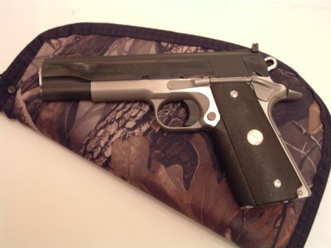 1995 Mercury Grand Marquis - A Colt 1911 pistol rests on a camouflage fabric case.