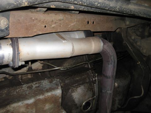 1995 Ford Bronco - Underside view of a vehicle's exhaust system components, including the muffler and pipes.