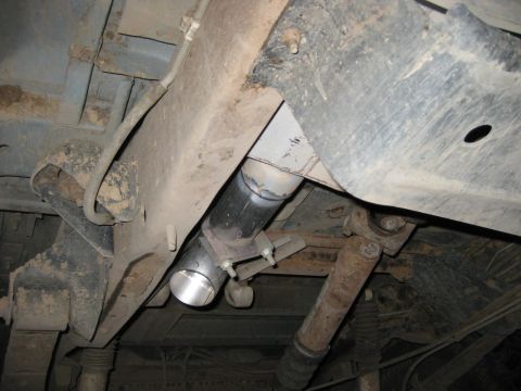1995 Ford Bronco - A custom exhaust pipe section is being fitted to the underside of a vehicle.