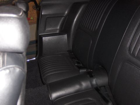 1970 Chevrolet Camaro - The black vinyl interior of a car, showing the rear seats and side paneling.