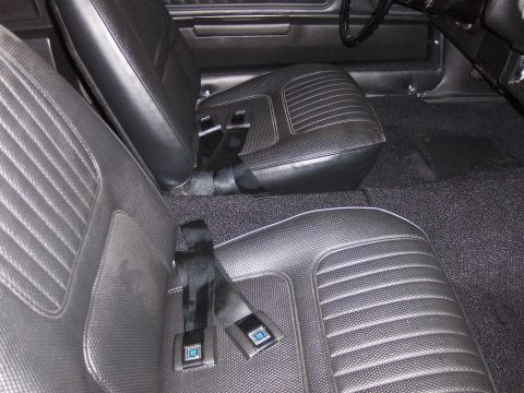 1970 Chevrolet Camaro - The interior of a 1970 Chevrolet Camaro shows black vinyl bucket seats with seat belts and dark carpeting.