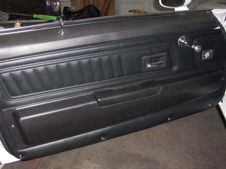 Black 1970 Chevrolet Camaro interior door panel with chrome window crank and door handle