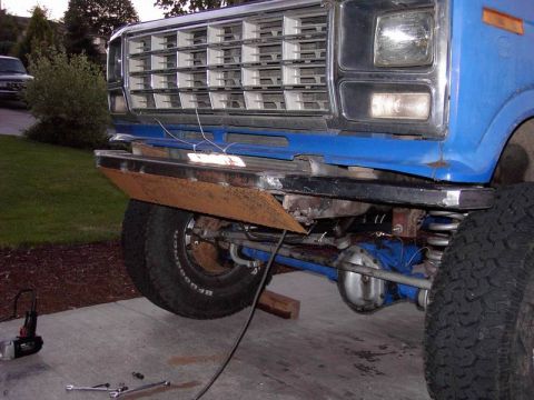 1980 Ford Bronco - Custom bumper project on a blue pickup truck, likely a 1979 Ford F-Series, with front suspension visible.