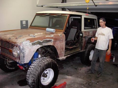 1980 Ford Bronco - A man stands by a Ford Bronco that is being worked on in a garage.