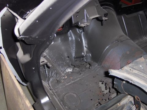 1970 Chevrolet Camaro - Interior view of a car's floor pan and wheel well, showing signs of rust and undercoating.