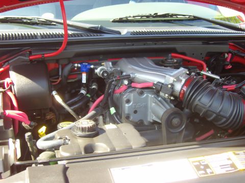 2007 Ford Mustang - Close-up view of a vehicle's engine bay, showing a supercharger and various hoses.