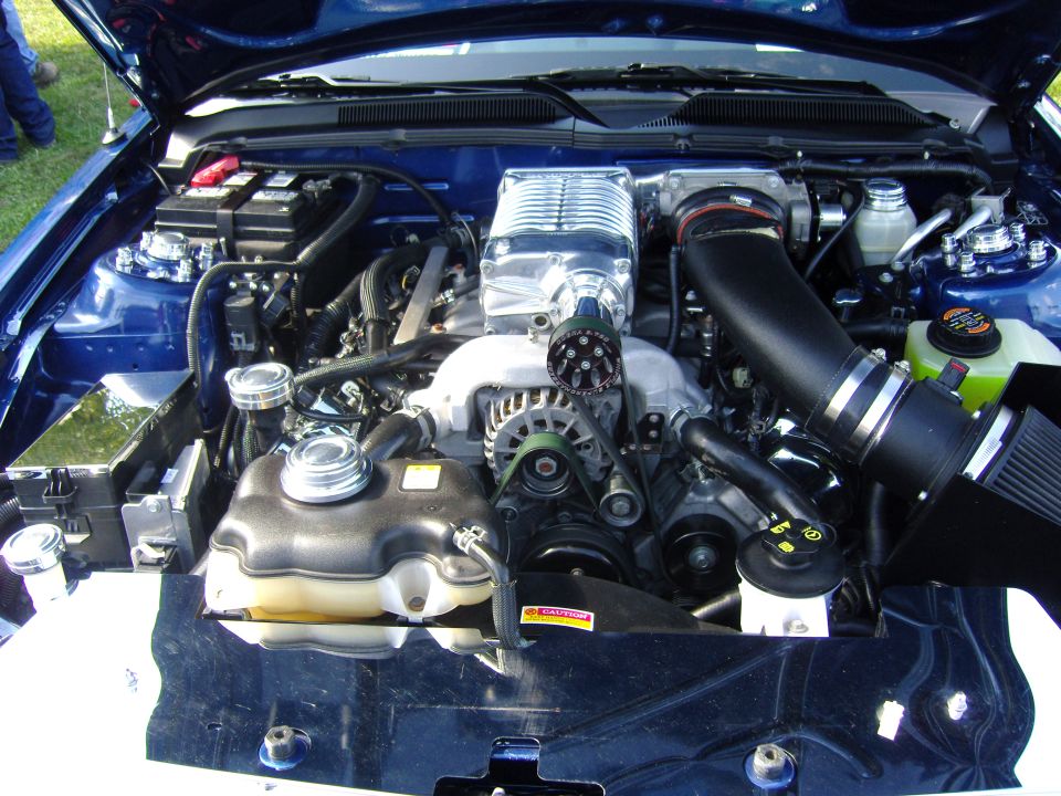 Blue engine bay with polished supercharger and black intake. 2007 Ford Mustang
